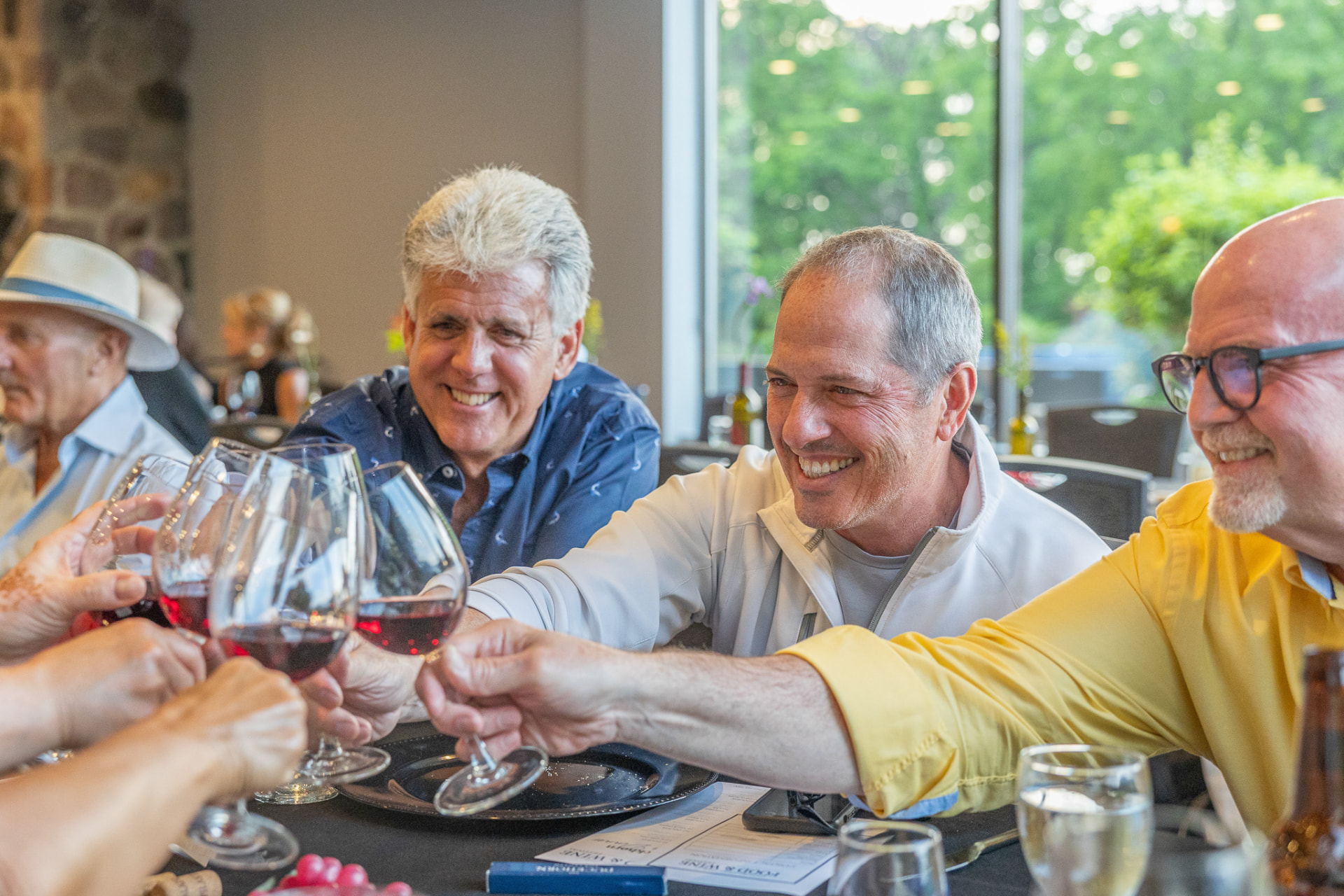 Guests raising glasses of wine together at a table in the dining room